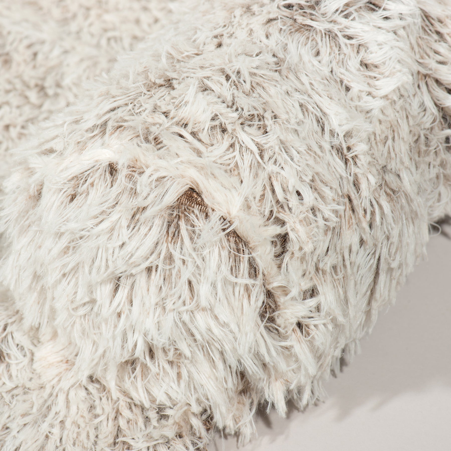 Close-up of a fluffy white pillow on a neutral background