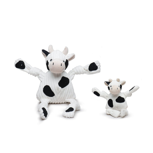 Two cow-themed toys, one larger and one smaller, on a white background.
