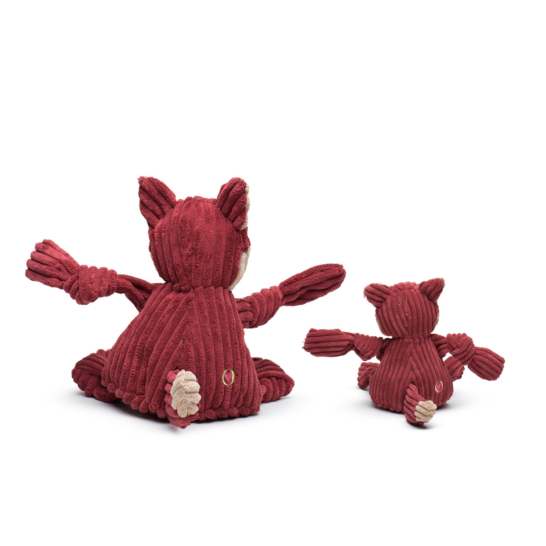 Two red plush toys resembling animals on a white background