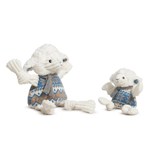Two plush toys resembling seals wearing knitted sweaters on a white background