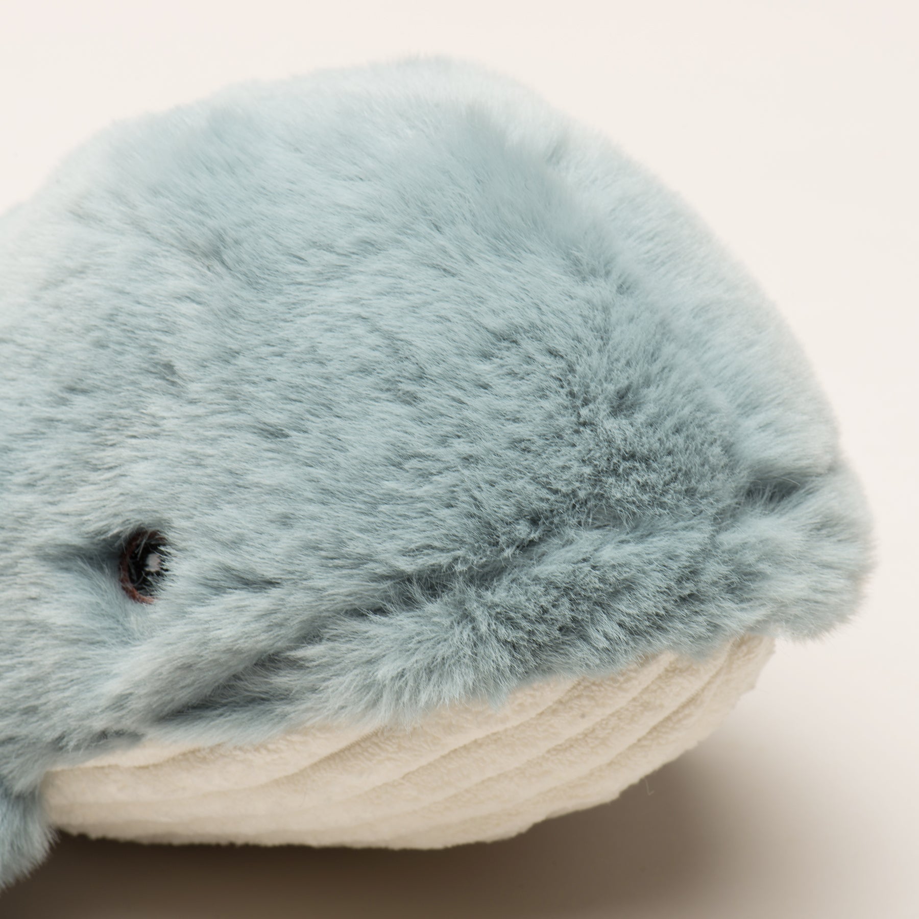 Plush toy whale with a soft texture on a light background