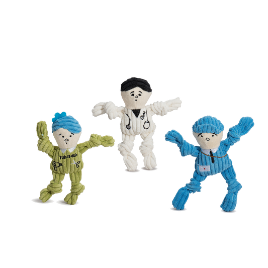 Three colorful dog toys with different outfits on a white background