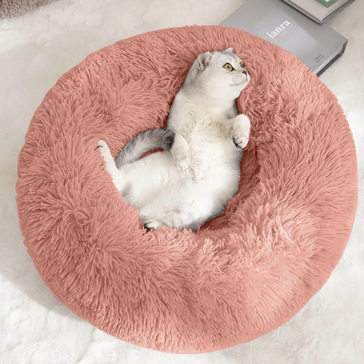 Cat lying on a fluffy pink pet bed