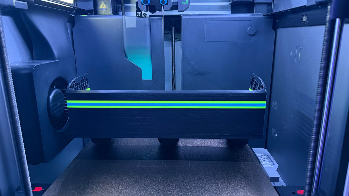 3D printer in operation with a blue tint