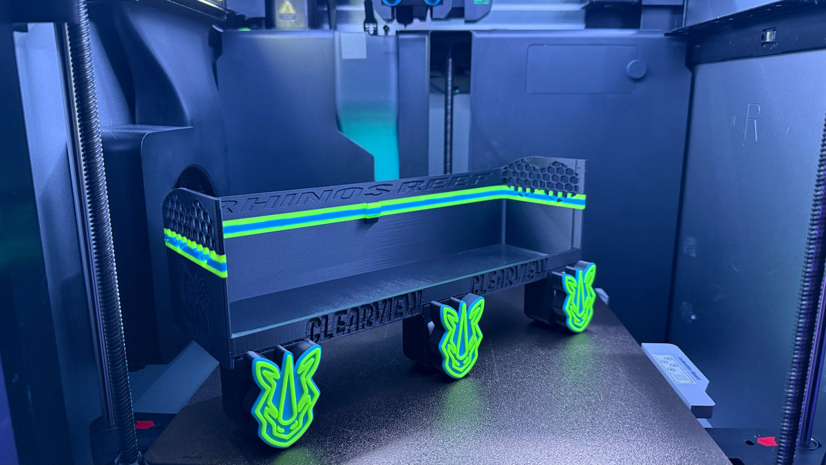 3D printed object with glowing green accents on a printer bed