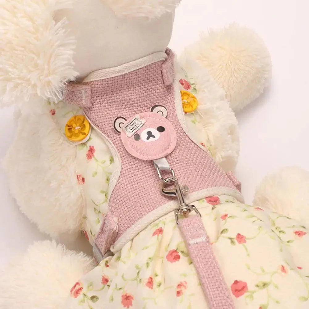 Pink dog harness with bear design on a floral-patterned blanket