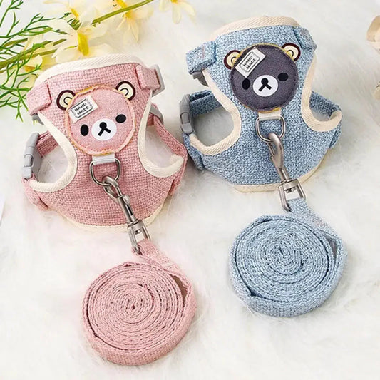 Two dog harnesses with leashes, one pink and one blue, on a light background.