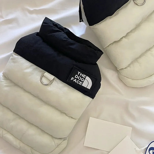 Black dog coat with 'The Dog Face' logo on a white surface