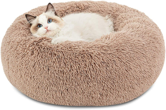 Cat lying on a fluffy beige donut bed