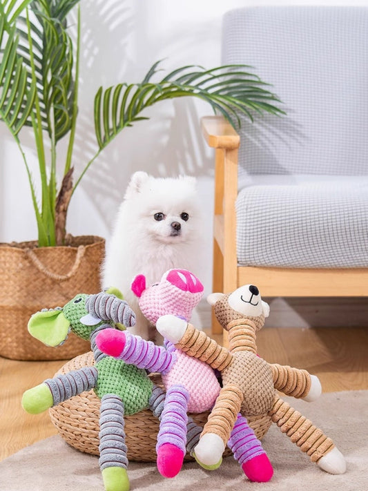 White dog with colorful plush toys on a carpeted floor in a living room setting.