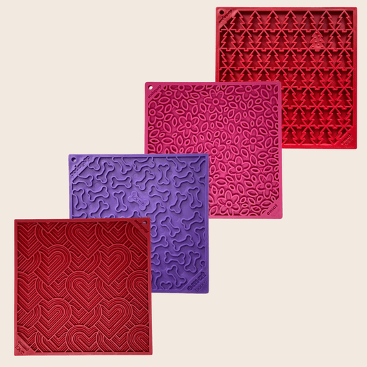 Four textured silicone mats in red, purple, and pink on a beige background