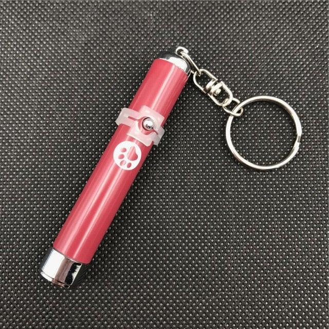 Pink keychain with a metal clip on a textured black background