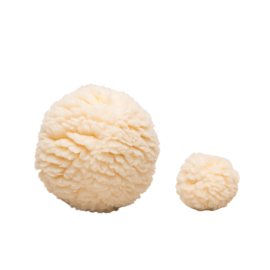 Two beige pom-poms on a white background