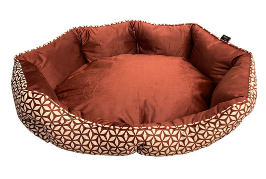 Brown pet bed with geometric patterned border on a white background